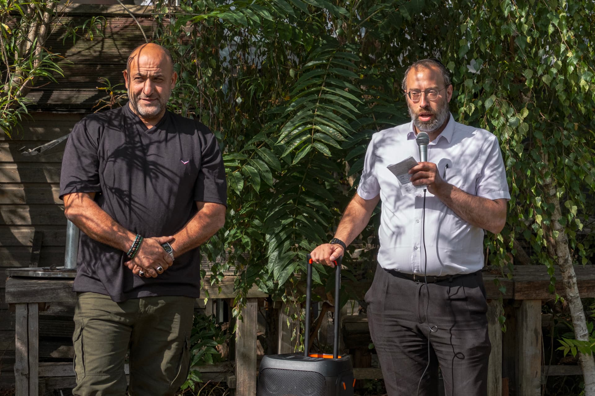 Two community members giving speeches at the garden opening