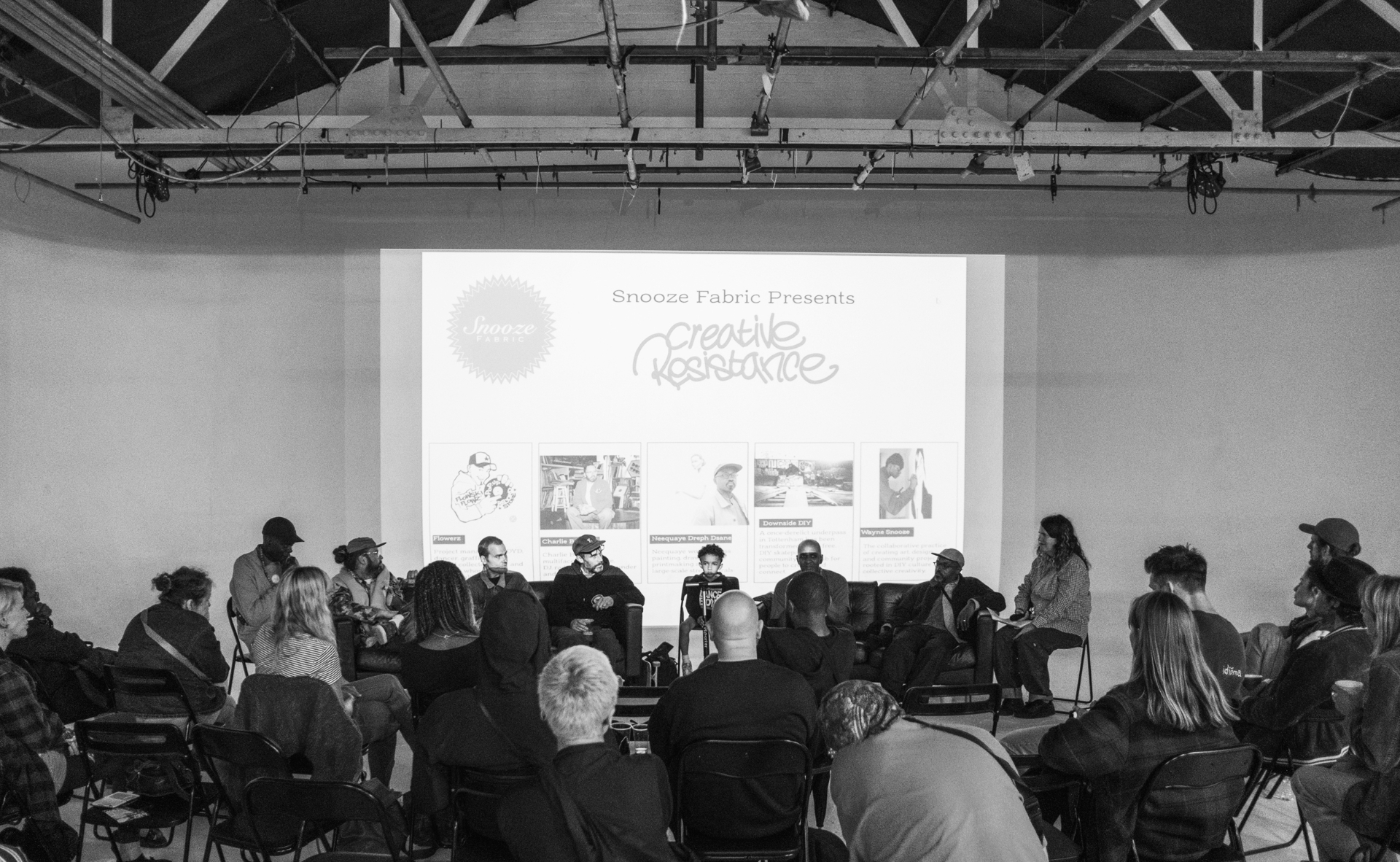 Audience gathered around the Creative Resistance panel with the Snooze Fabric slide projected behind.