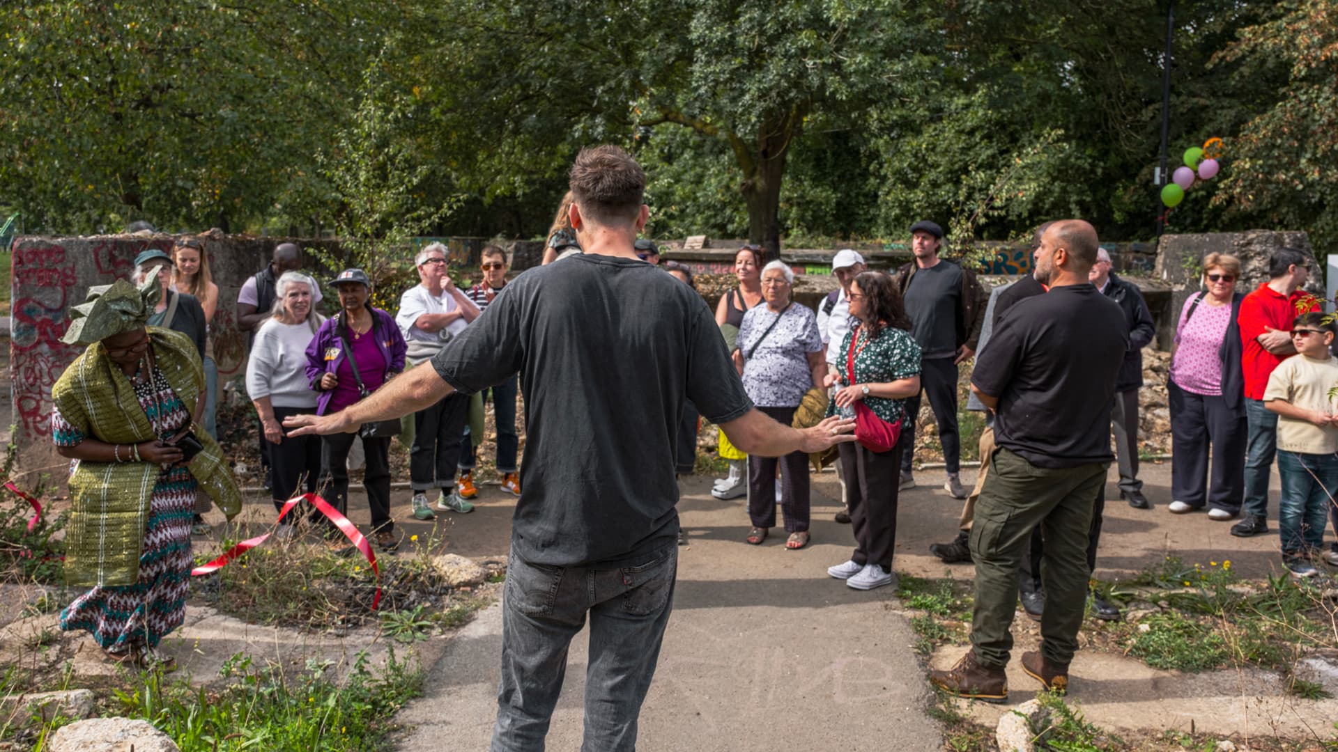 A crowd gathered around a red ribbon for the garden's official opening