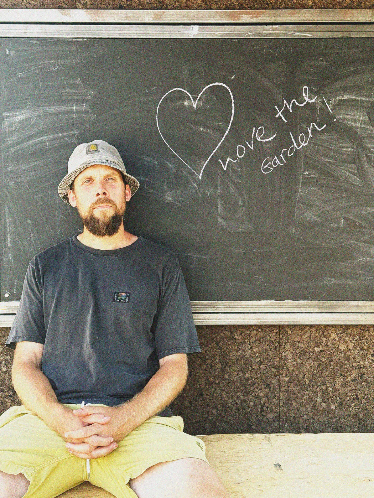 Steve Williams sat by a chalkboard reading 'love the garden'