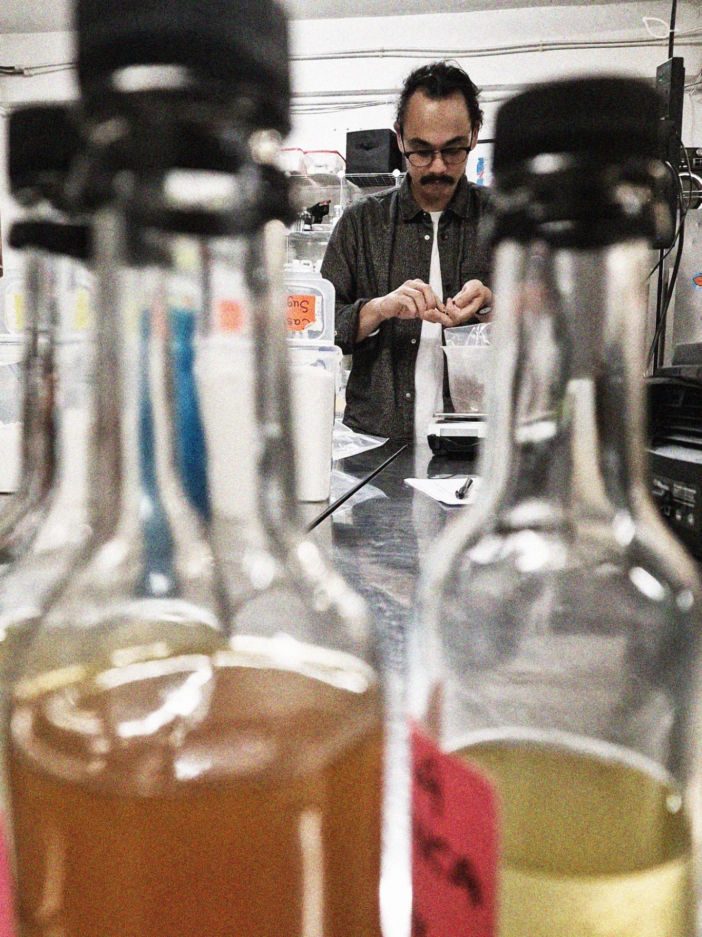 Distilling the spritz at Crucible — bottles in the foreground, maker weighing ingredients behind.